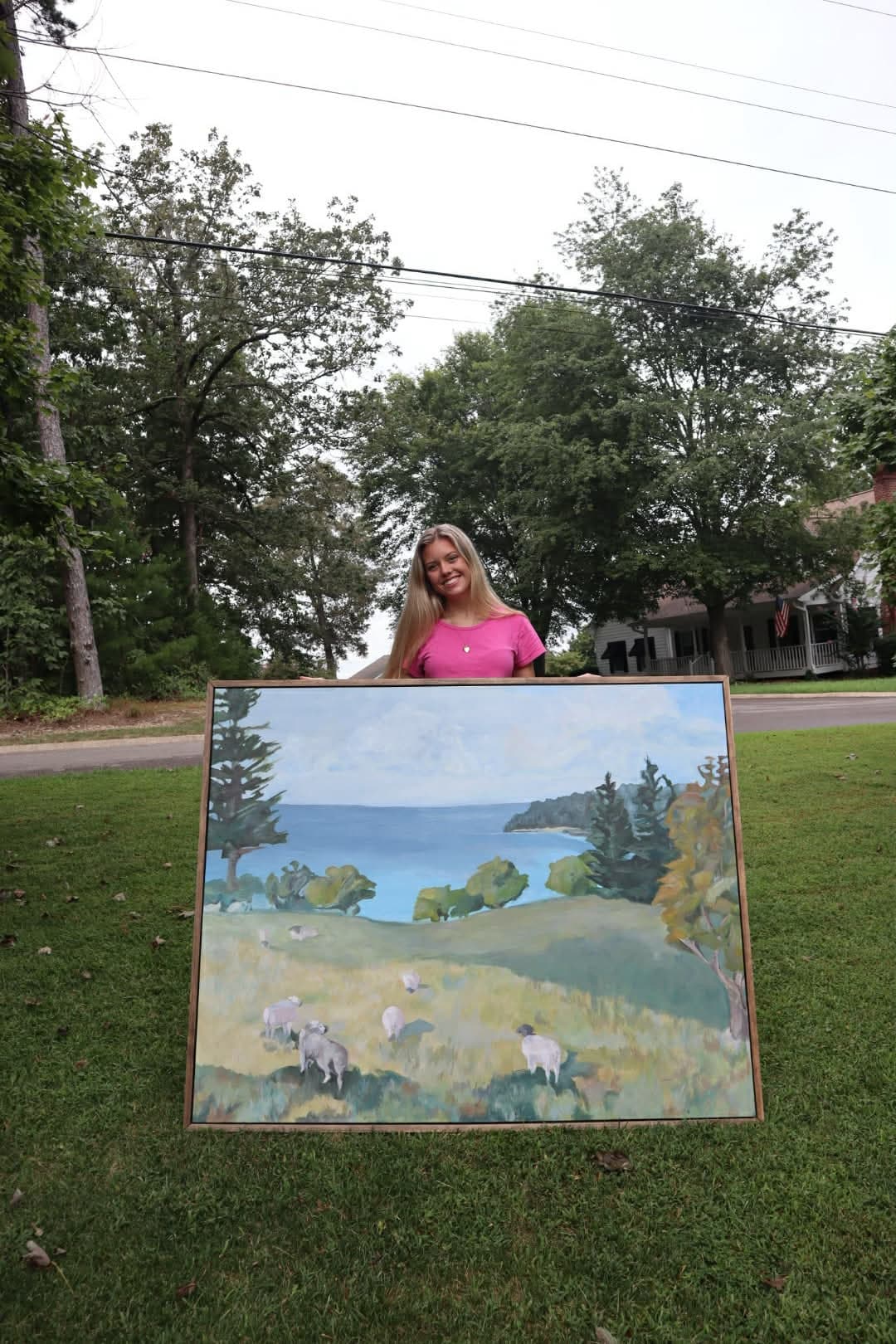 Artist holding sheep painting